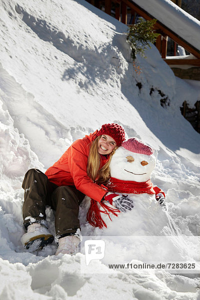 Woman with arms around snowman