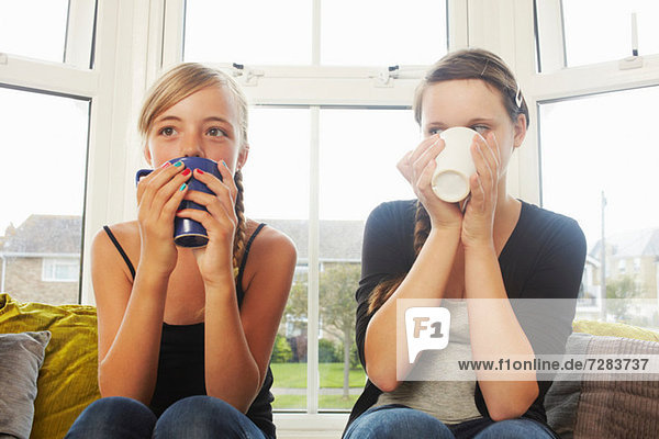 Two girls drinking hot drinks
