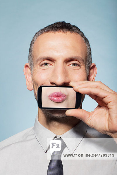 Mann bedeckt Mund mit Smartphone  Mund