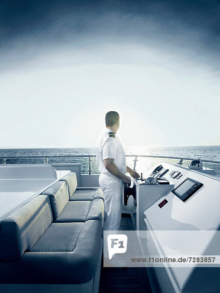Captain at helm of large motor yacht