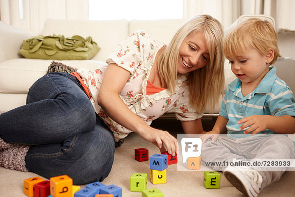 Mother and son playing with alphabet blocks