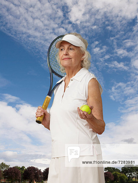 Porträt einer älteren Frau mit Tennisausrüstung