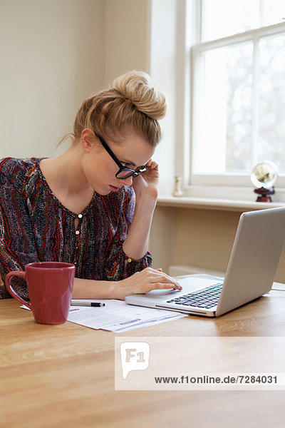 Young woman wearing glasses  using laptop