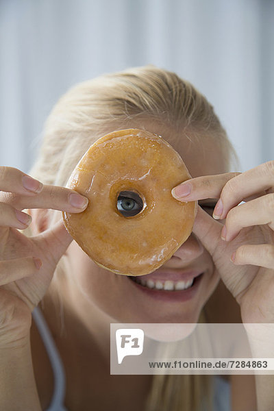 Frau blickt durch das Donutloch