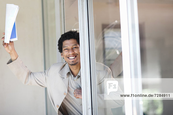Businessman leaning in glass door