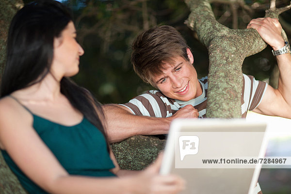 Couple using laptop outdoors