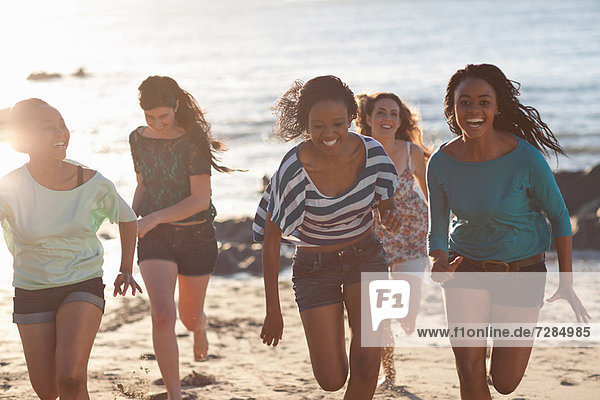 Women running together on beach