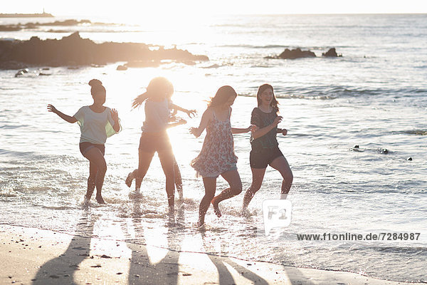 Women running together on beach
