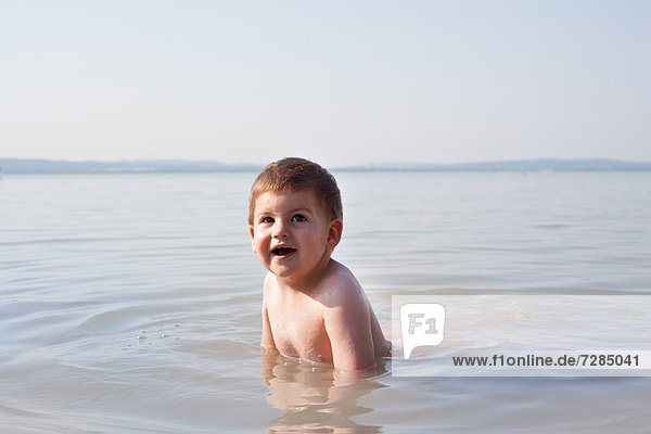 Junge spielt im Wasser im Freien