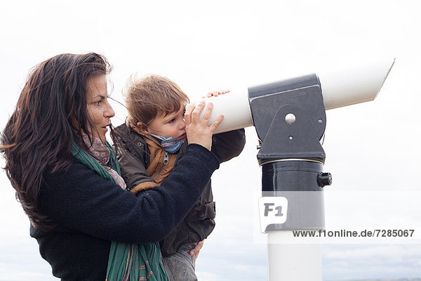 Mutter und Sohn schauen durchs Teleskop