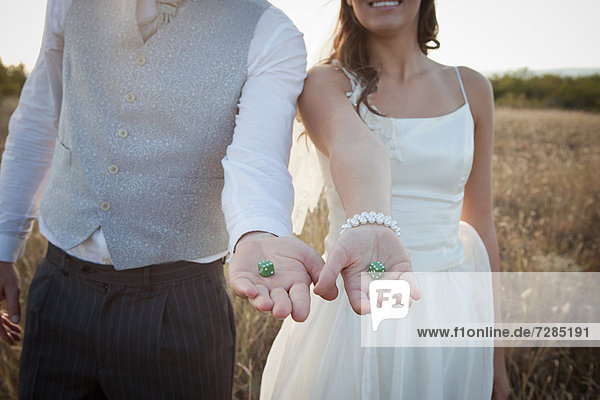 Newlywed couple holding green dice