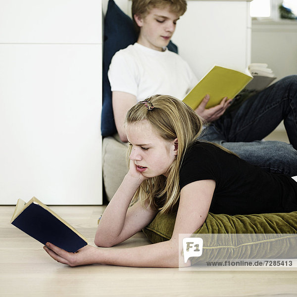 Kinder lesen im Wohnzimmer