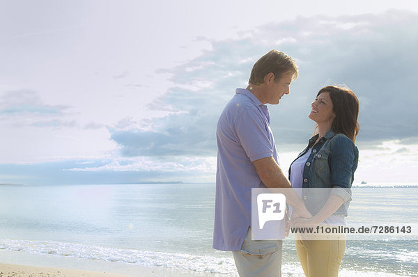 Couple holding hands on beach