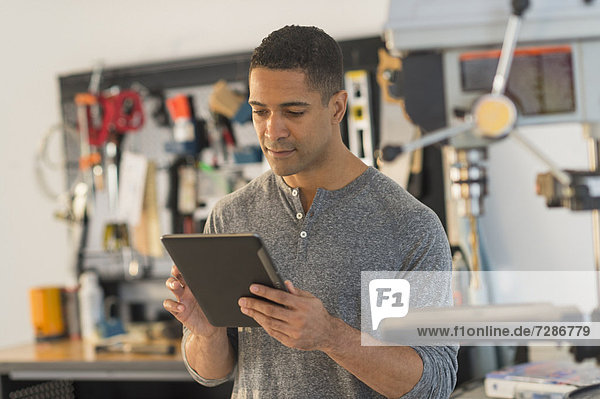 Man with digital tablet in workshop