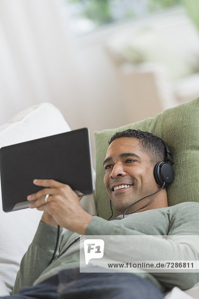 Mann  zuhören  Couch  Musik  Tablet PC