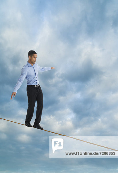 Man balancing on tightrope  studio shot