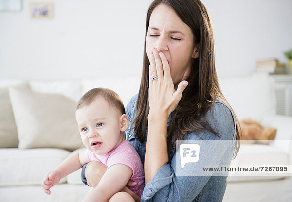 Mother with daughter (6-11 months) sitting in living room