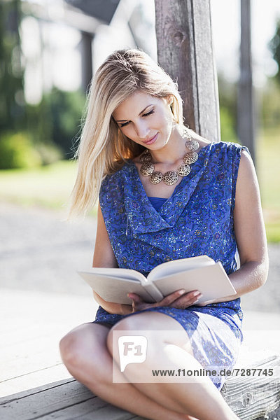 Portrait of woman reading book outdoors