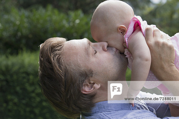 Menschlicher Vater  küssen  Tochter  Baby