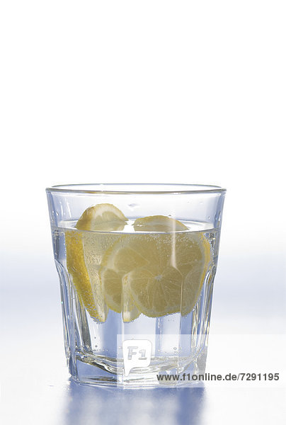 Glass of water with lemon slice on white background