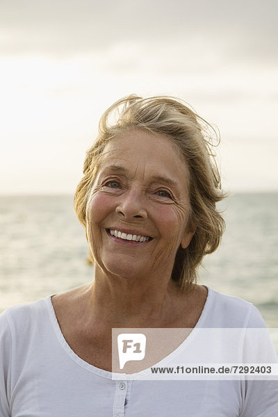 Spain  Senior woman at the sea  smiling