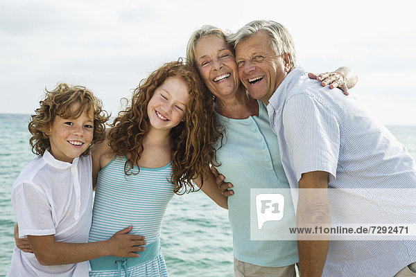 Spain  Grandparents with grandchildren at the sea  smiling  portrait