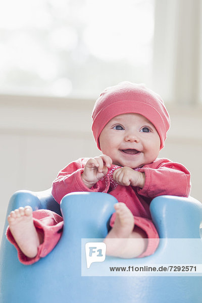 Smiling Caucasian baby sitting in chair