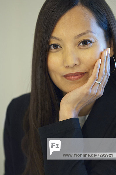 Asian businesswoman with head in hands