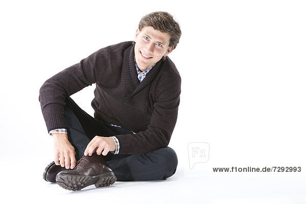 Young man tying shoes  close up