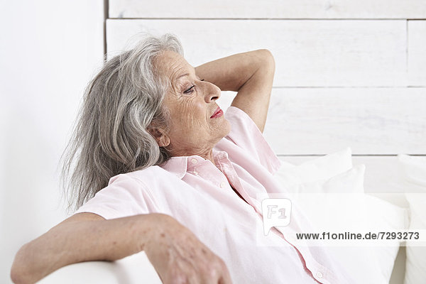 Spanien,  Seniorin entspannt auf der Couch
