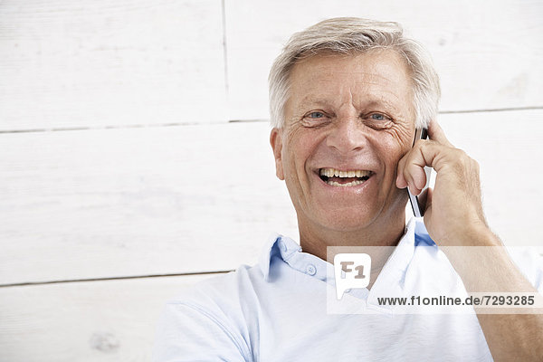 Spanien  Senior auf dem Handy  lächelnd  Portrait