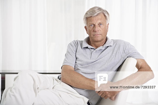 Spanien,  Mallorca,  Trauriger älterer Mann auf der Couch sitzend