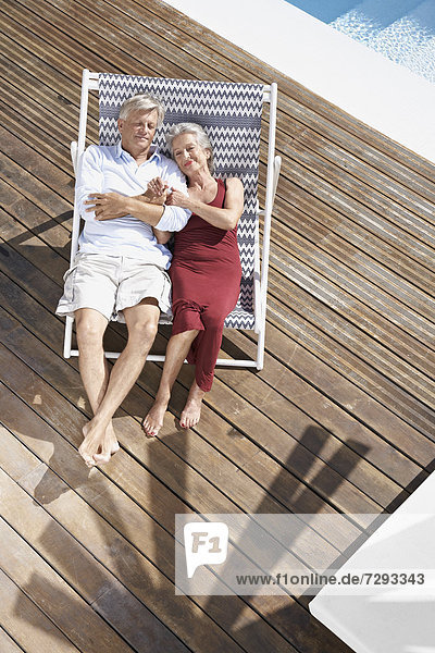 Spain  Senior couple relaxing on deck chair at beach