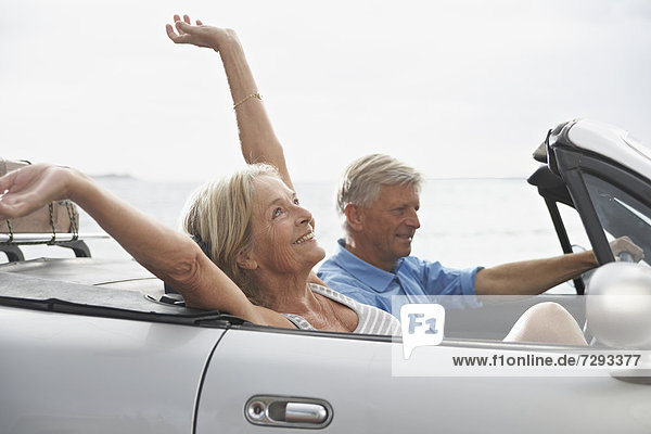 Spain  Senior couple in convertible car  smiling