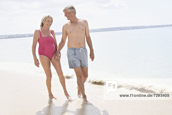 Spain  Mallorca  Senior couple walking on beach
