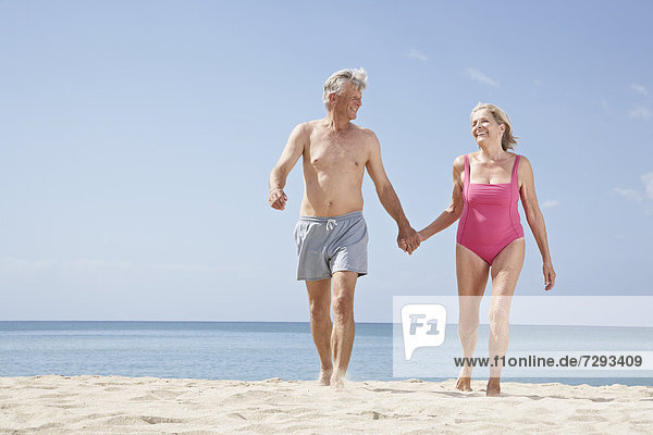 Spain  Mallorca  Senior couple walking on beach