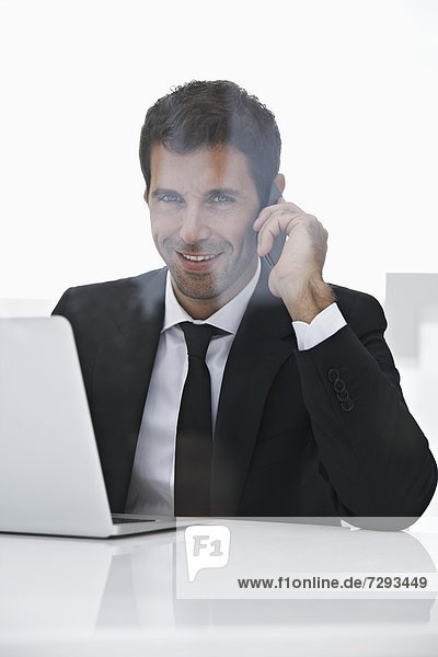 Spain  Businessman talking on mobile phone  smiling