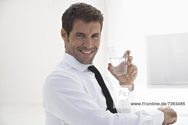 Spain  Businessman holding water glass  smiling  portrait