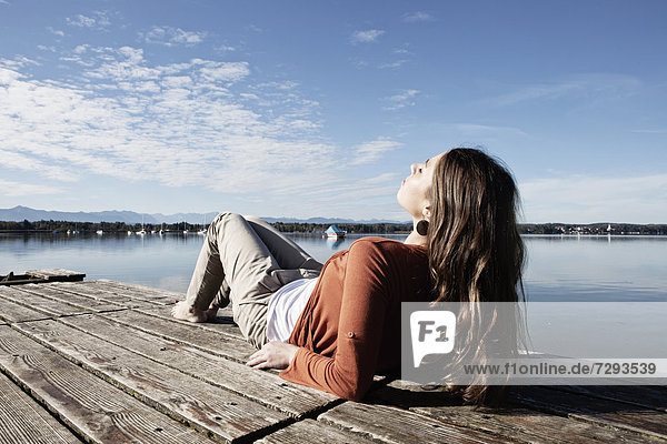 Young woman sitting on jetty