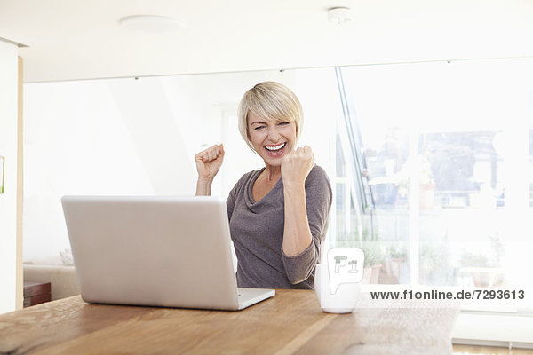 Woman happy while using laptop
