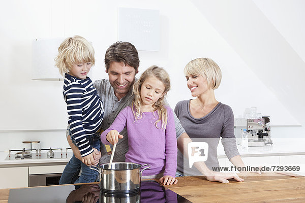 Deutschland  Bayern  München  Familie bei der Zubereitung von Speisen in der Küche
