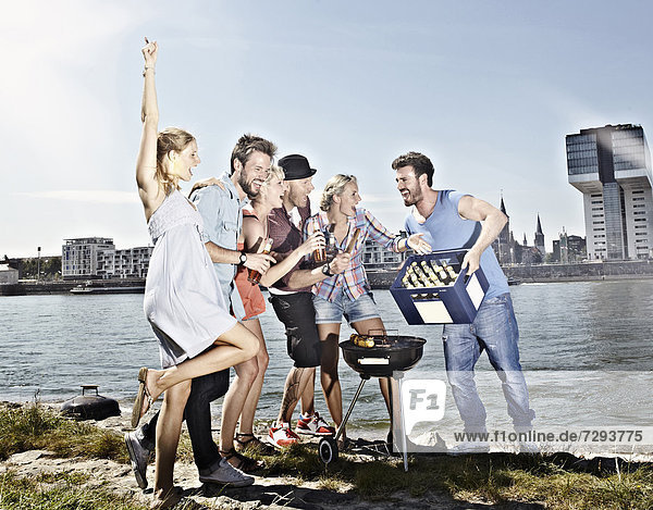 Germany,  Cologne,  Group of people gathered around barbecue