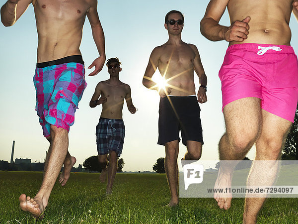 Germany Duesseldorf Young friends running on meadow