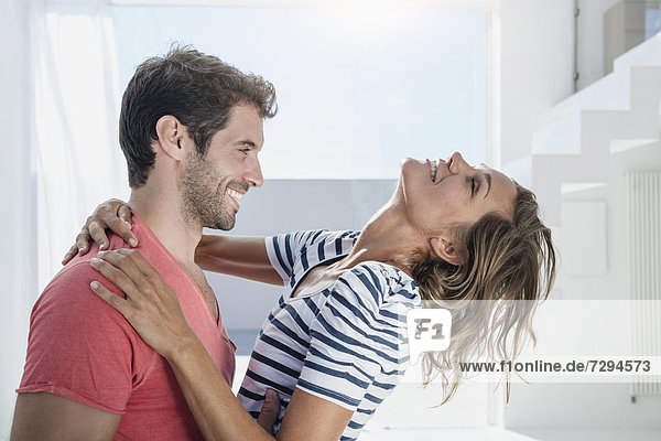 Spain  Mid adult couple embracing each other in modern apartment