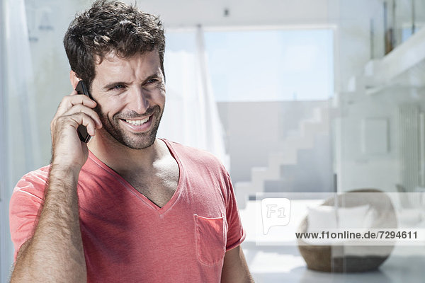 Spain  Mid adult man talking on cell phone  smiling