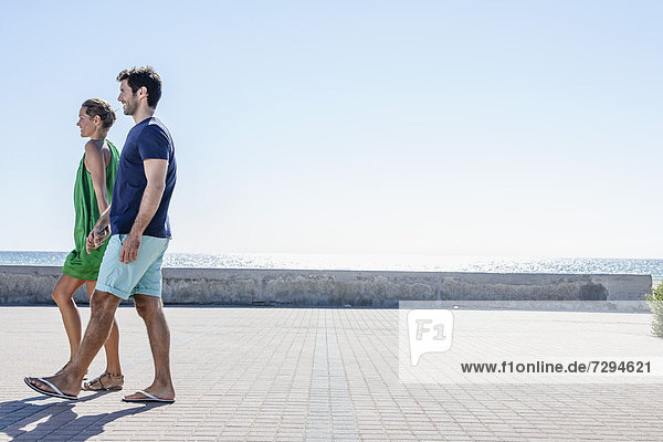 Spain  Mid adult couple walking on pavement