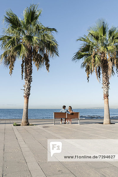 Spanien  Mittleres erwachsenes Paar auf der Bank sitzend