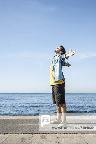 Spain  Mid adult man standing at Atlantic Ocean