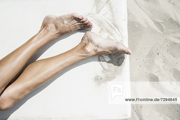 Spain  Human legs on beach towel