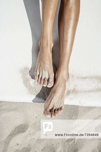 Spain  Human legs on beach towel